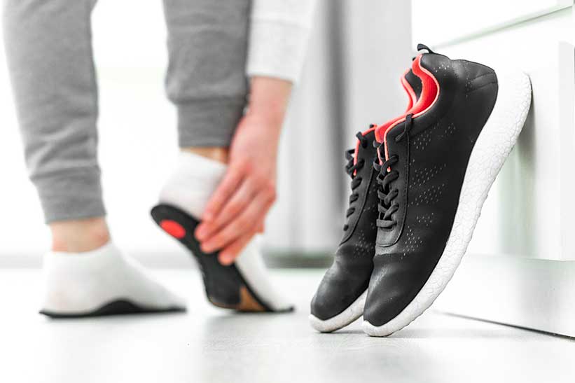 Person fitting orthotics for running shoes