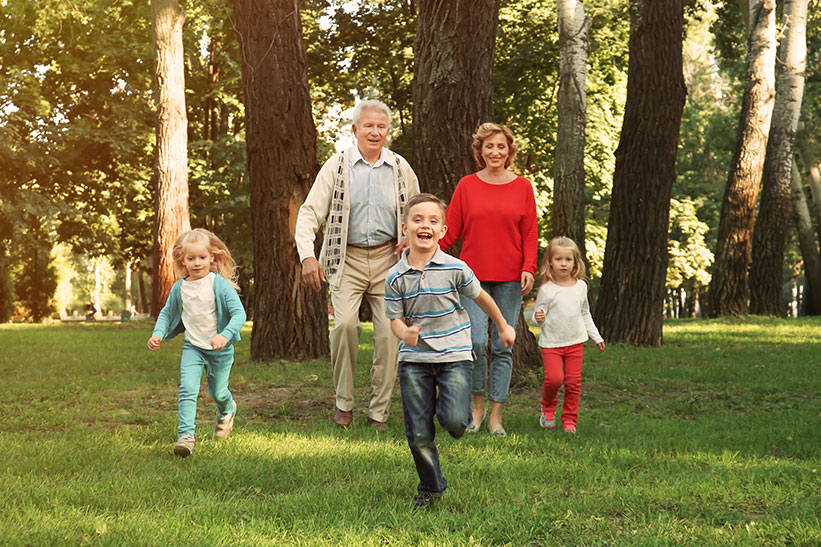 Grandchildren running in park with grandparents
